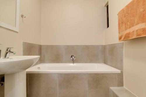un baño con lavabo y bañera en GroundEazy beside Mall of Africa, en Midrand