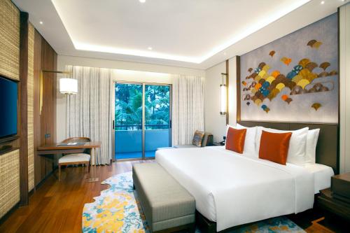 a bedroom with a large white bed and a large window at Mason Pine Hotel Bandung in Padalarang