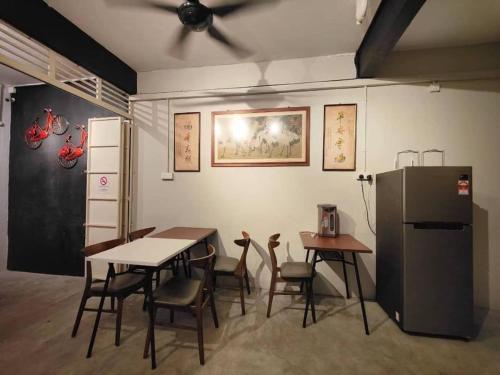 ジョージタウンにあるSunshine Houseのテーブルと椅子、冷蔵庫が備わる客室です。