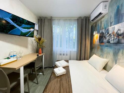 a room with a desk and a bed and a table at MYFREEDOM Апартаменти метро Кловська, Військовий Госпіталь in Kyiv