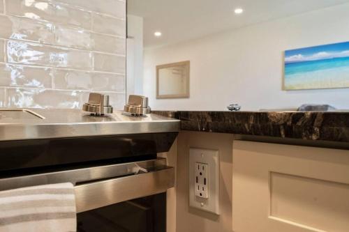 a kitchen with a sink and a counter at Hale Ono Loa 403- Top floor, Ocean view, & complete modern remodel in Kahana