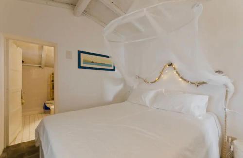 una camera da letto con un letto bianco e un bagno di Rustico al mare a Capo Mulini
