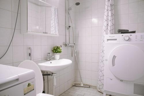 biała łazienka z toaletą i umywalką w obiekcie Railway&bus station studio w mieście Oulu
