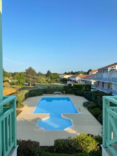 - une vue sur la piscine dans la cour dans l'établissement Unappartalamer Vue Golf de Pornic et piscine, à Pornic