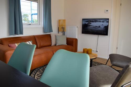 a living room with a couch and a tv at Camping Duin en Strand in Scharendijke