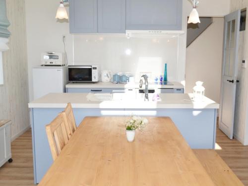 a kitchen with a wooden table and a kitchen with blue cabinets at Tree Village Karuizawa in Karuizawa