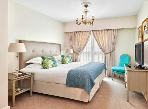 - une chambre avec un lit, une télévision et une chaise dans l'établissement La Résidence de La Réserve, à Beaulieu-sur-Mer