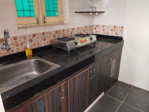 a kitchen with a sink and a stove at pavan's villa in Hampi