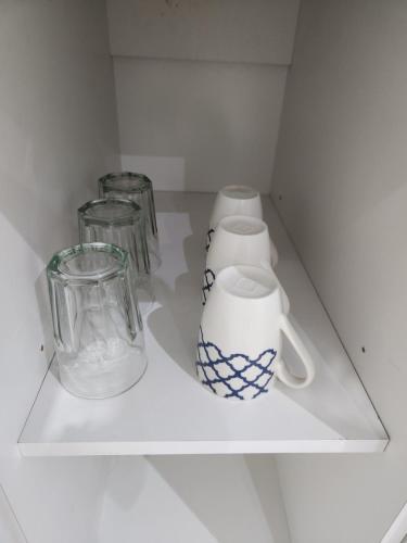 un estante blanco con artículos de vidrio. en Luz de Luna en Plottier