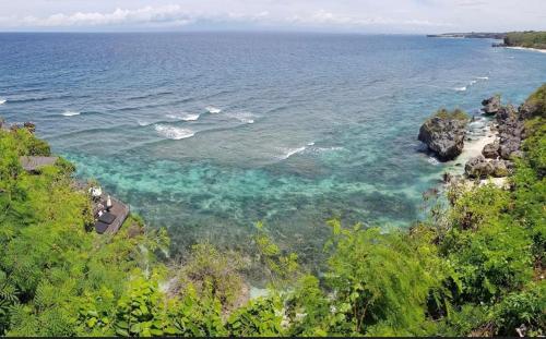 Una vista aérea de una playa con rocas y agua. en Hidden Gem Uluwatu Apartments, en Uluwatu