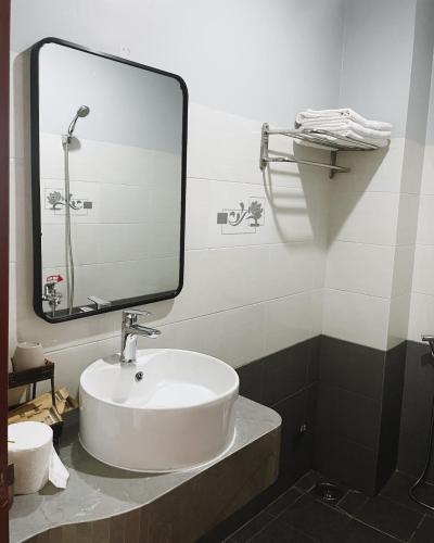a bathroom with a sink and a large mirror at Phuong Nam Hotel An Giang in Long Xuyên