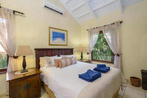 San Lameer Villa 2909 في ساوثبروم: غرفة نوم عليها سرير وفوط زرقاء