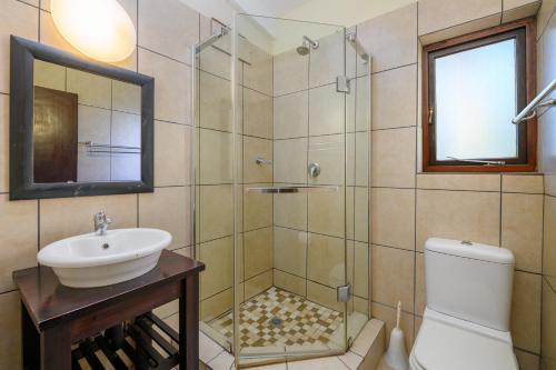 a bathroom with a shower and a sink and a toilet at San Lameer Villa 2909 in Southbroom