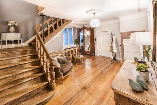 sala de estar con escalera y sofá en Le Clos Marguerite - Maison d'Hôtes, en Ammerschwihr