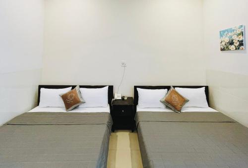 two beds sitting next to each other in a room at Phuong Nam Hotel An Giang in Long Xuyên
