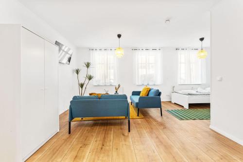 sala de estar con 2 sillas azules y sofá en Chic & Modern Apartment, en Jüterbog