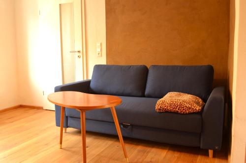 a blue couch and a table in a room at Lehmhäuschen mit Sauna in Tangermünde