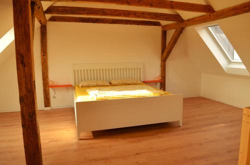 a bedroom with a bed in an attic at Lehmhäuschen mit Sauna in Tangermünde