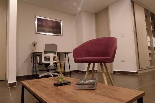 sala de estar con silla roja y mesa en Apartamento Moderno, en Pereira
