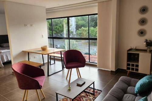 sala de estar con mesa, sillas y sofá en Apartamento Moderno, en Pereira