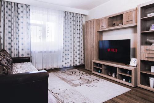 - un salon avec un canapé et une télévision dans l'établissement Best Apartment Central, à Hunedoara