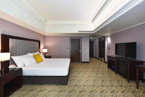 a hotel room with a bed and a flat screen tv at Fullon Poshtel - Linkou in Guishan