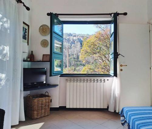 Habitación con ventana grande y TV. en Casa Marina - Tenuta Calano, en Celle Ligure