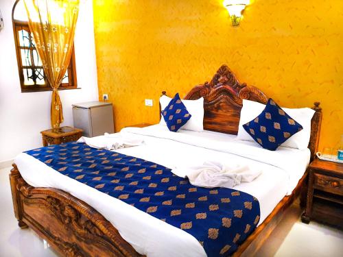 a bedroom with a large bed with blue and white pillows at Veronica By The Beach Calangute in Calangute
