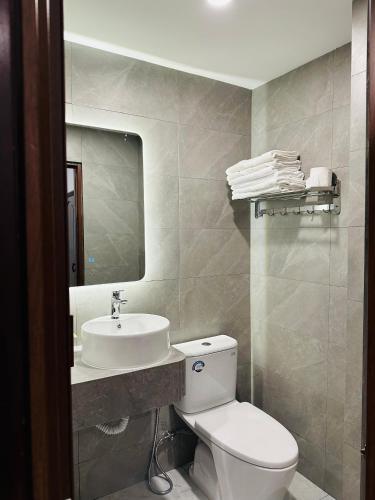 a bathroom with a white toilet and a sink at Phuong Nam Hotel An Giang in Long Xuyên