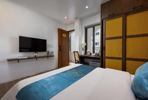 a bedroom with a large bed with a tv on the wall at Cat Ba Green Pearl Hotel in Cat Ba