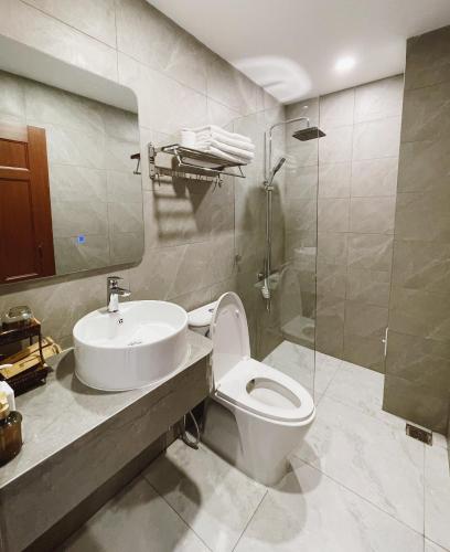 a bathroom with a toilet and a sink and a shower at Phuong Nam Hotel An Giang in Long Xuyên