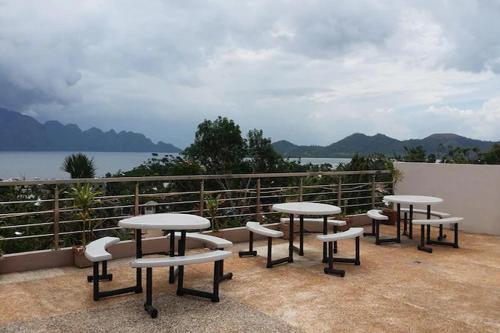 un gruppo di tavoli e sedie in cima a un balcone di Micasa Lodge a Coron