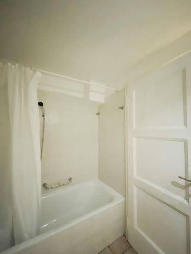 a white bathroom with a tub and a shower at Gotthard House in Lugano