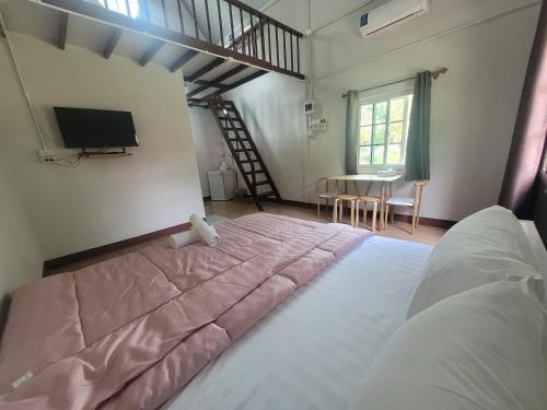 a bedroom with a large bed and a tv at Sawan Srang Nang Kaew in Takhop