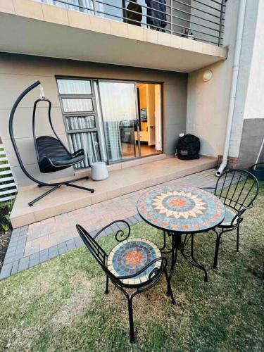 a patio with two chairs and a table and a swing at The Steynview Pad - Pvt Garden Unit w/ Power Backup in Sandton