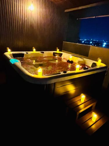 a bath tub with lit candles in a room at SScoconest Luxury Service Apartments in Chikmagalūr