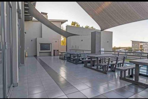 a patio with tables and benches on a building at The Steynview Pad - Pvt Garden Unit w/ Power Backup in Sandton