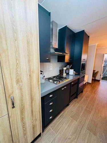 a kitchen with blue cabinets and a wooden floor at The Steynview Pad - Pvt Garden Unit w/ Power Backup in Sandton