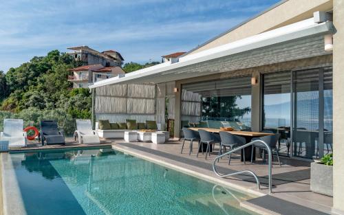a house with a swimming pool and a table and chairs at Nikiana Luxury Villas in Nikiana