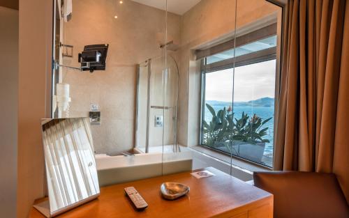 a bathroom with a desk and a window with a bath tub at Nikiana Luxury Villas in Nikiana