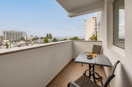 a balcony with a table and chairs and a window at Comfy Studio Turystyczna 300 m to the beach by Renters in Międzyzdroje