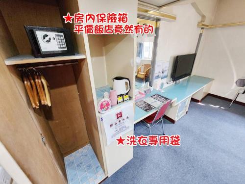 a small room with a desk and a computer at Hua Ku Hotel in Tainan