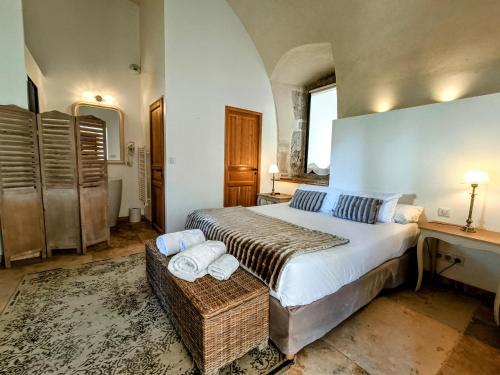 a bedroom with a bed and a desk with towels at Les Chambres De La Renaissance in Sainte-Julie
