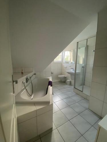 a white bathroom with a tub and a sink at Am Jungfernberg 2 in Rankwitz