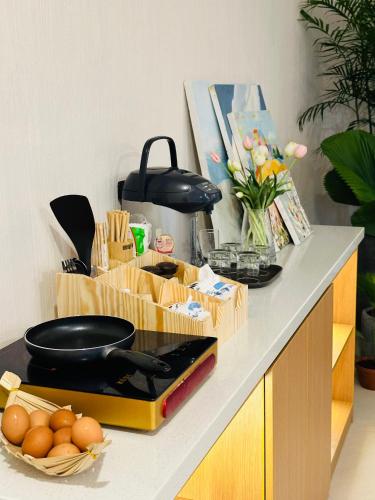 a kitchen counter with a table with food and vegetables at Phuong Nam Hotel An Giang in Long Xuyên