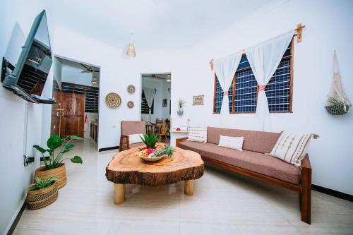 a living room with a couch and a table at ✰Secluded House w/King Bed near Beach-5 min walk✰ in Pingwe