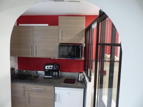 une petite cuisine avec un évier et un micro-ondes dans l'établissement Charmant logement près Parc Buttes Chaumont, à Paris