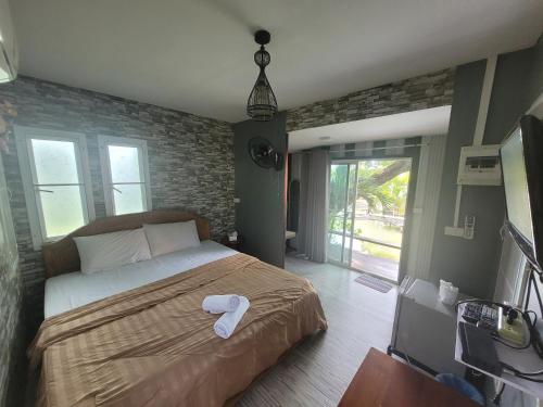 a bedroom with a bed with a white towel on it at Sawan Srang Nang Kaew in Takhop