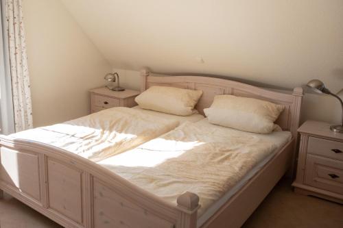 um quarto com uma cama branca e 2 almofadas em Am Jungfernberg 2 em Rankwitz