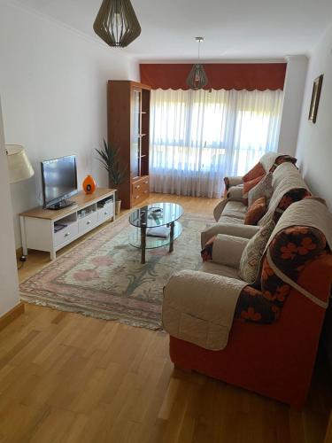 sala de estar con sofá y TV en Amplio y céntrico piso con buenas vistas en Selaya, en Selaya